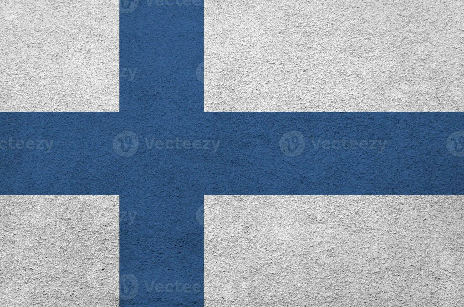 Finland flag depicted in bright paint colors on old relief plastering wall. Textured banner on rough background photo