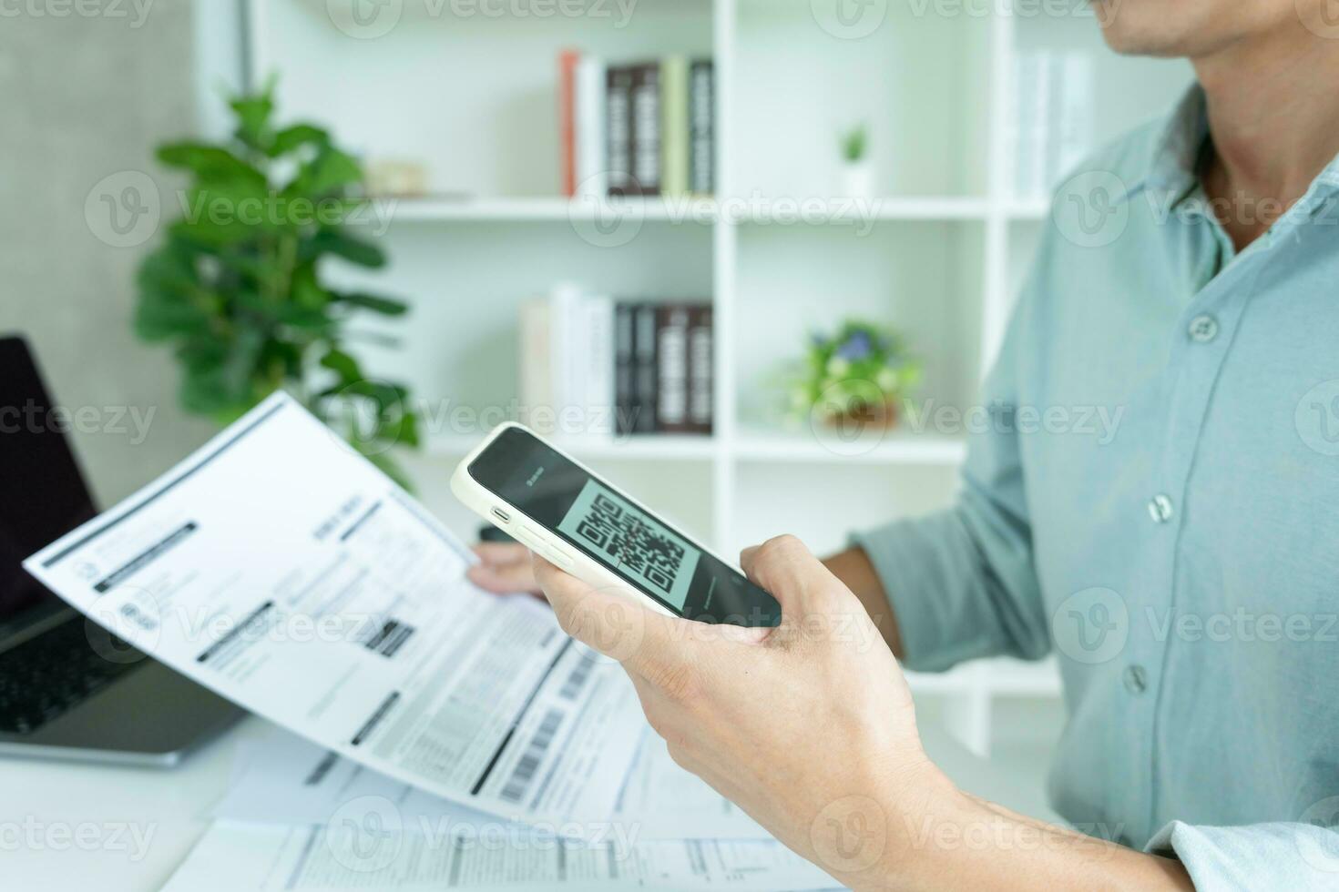 business man use phone to scan barcode or QR codes to pay credit card bill after receiving document invoice online. payment, receive, paying electricity, digital payments without money, technology photo