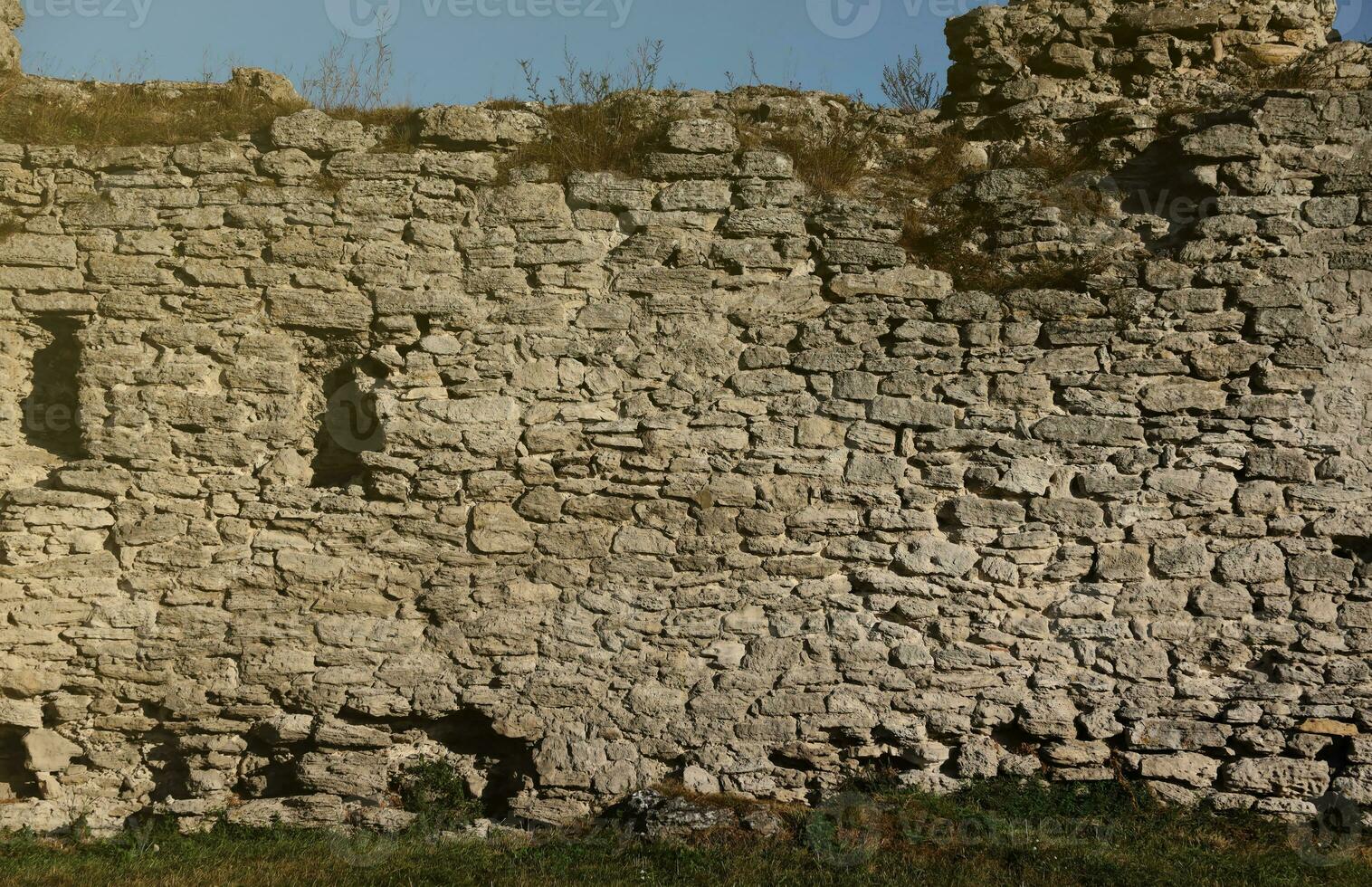 Very old brick stone wall of castle or fortress of 18th century. Full frame wall with obsolete dirty and cracked bricks photo
