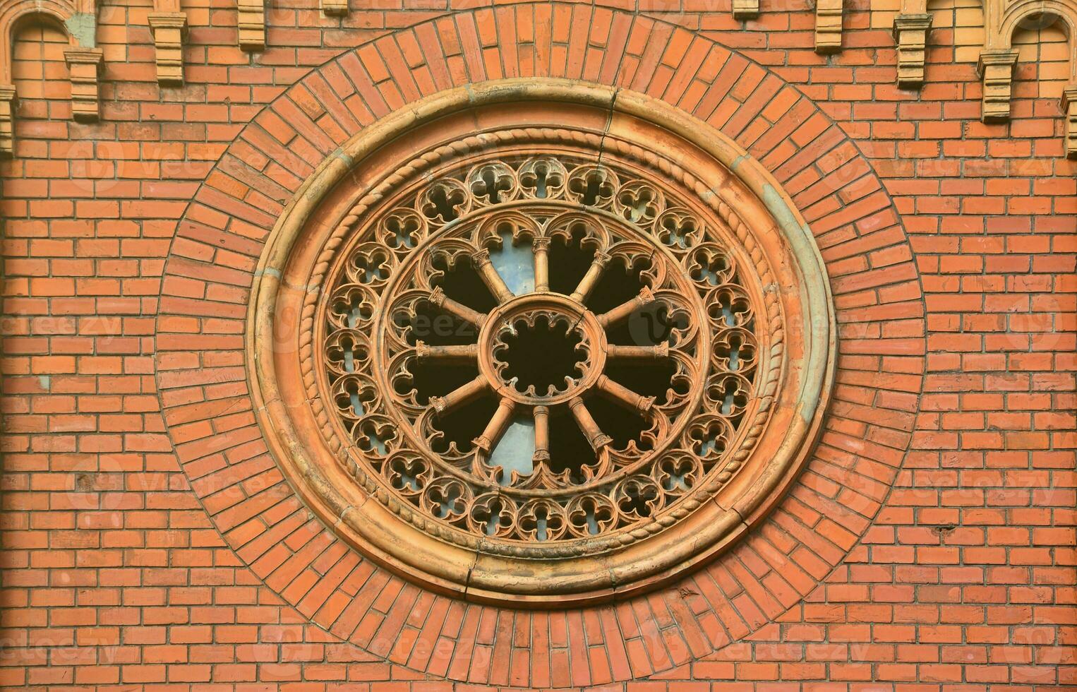 Texture front part of an ancient brick crypt with a round patterned carved window in the cemetery photo