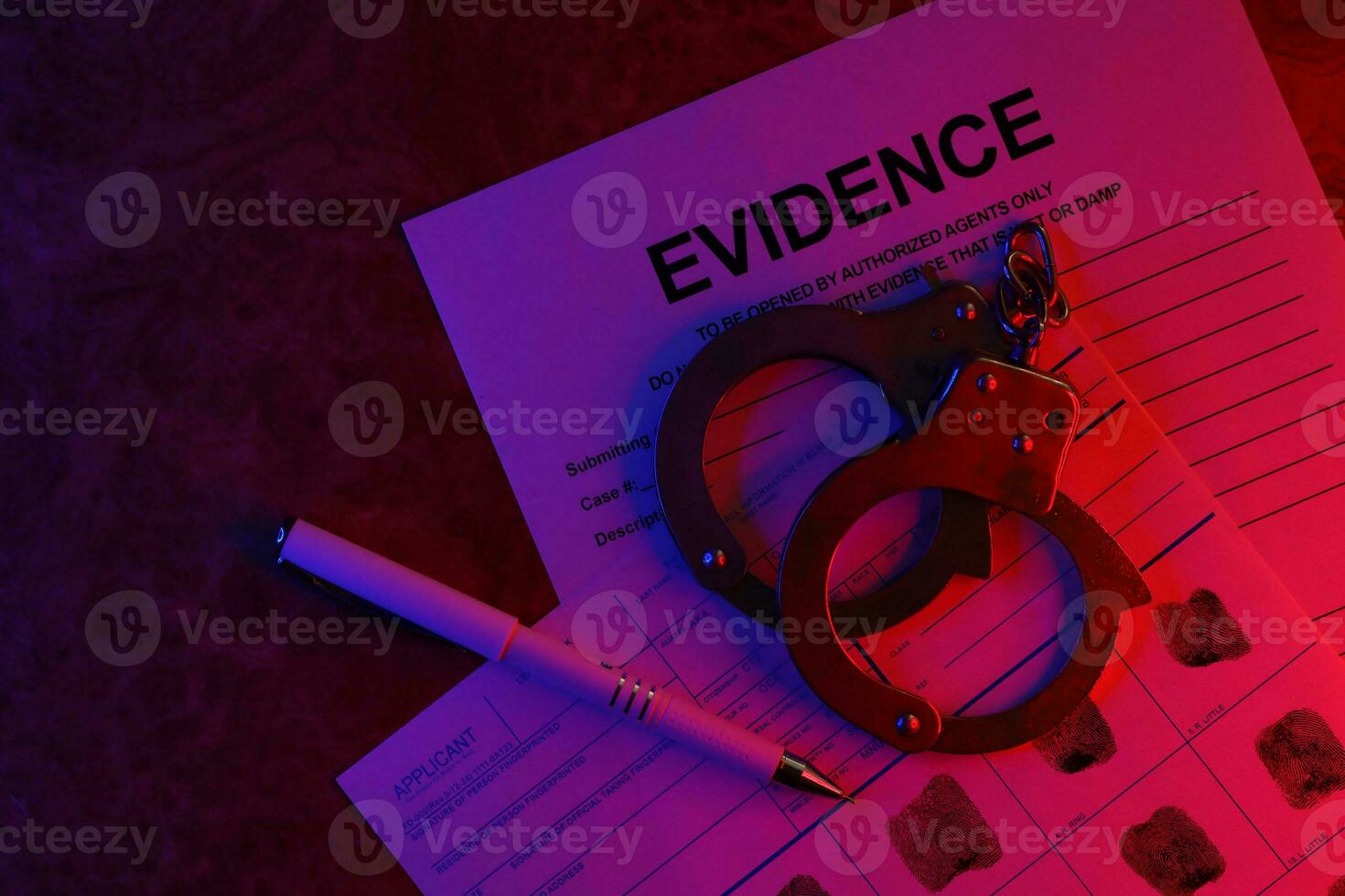 Applicant or fingerprints card with police handcuffs on table in dark room photo