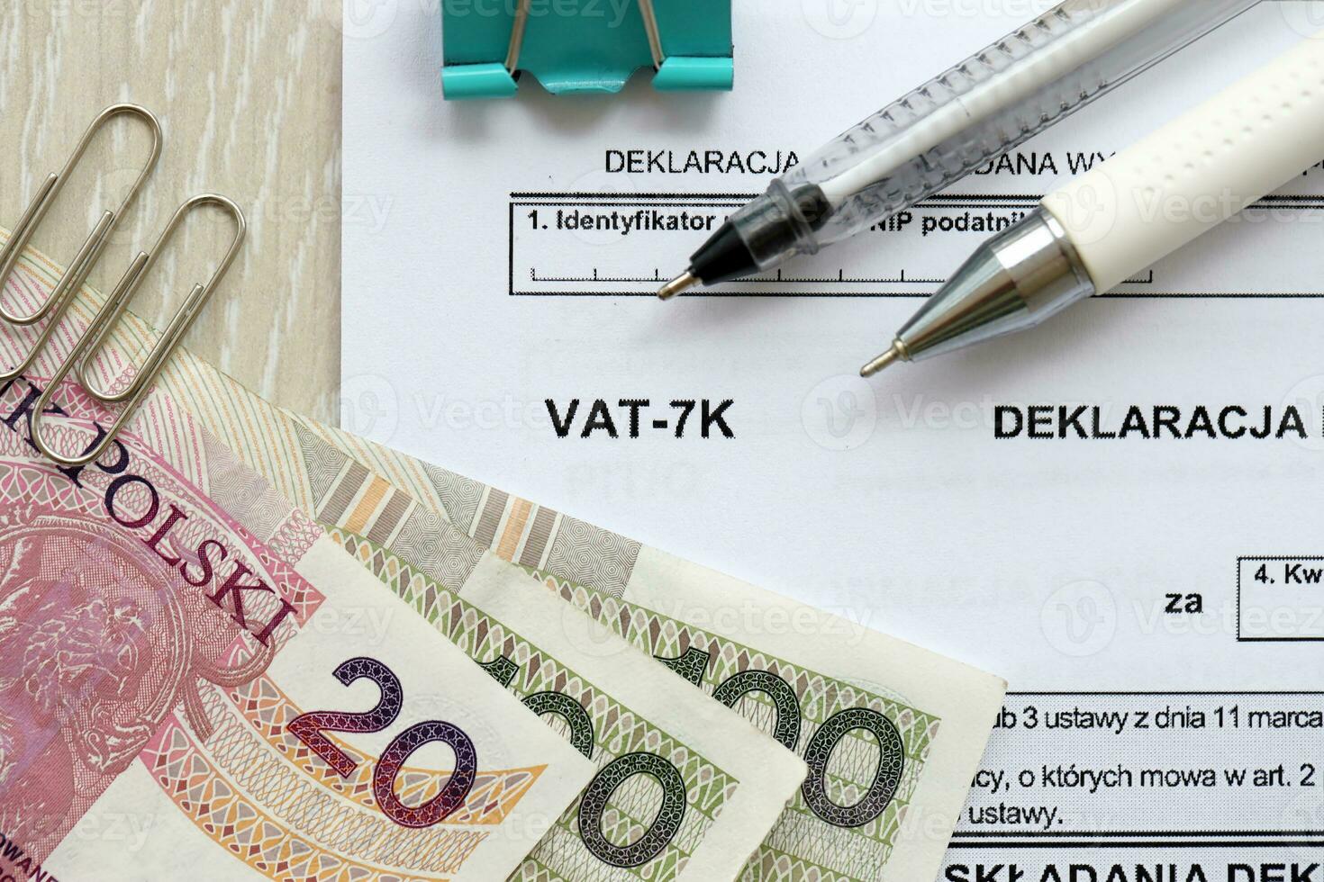 Declaration for tax on goods and services VAT-7K form on accountant table with pen and polish zloty money bills photo