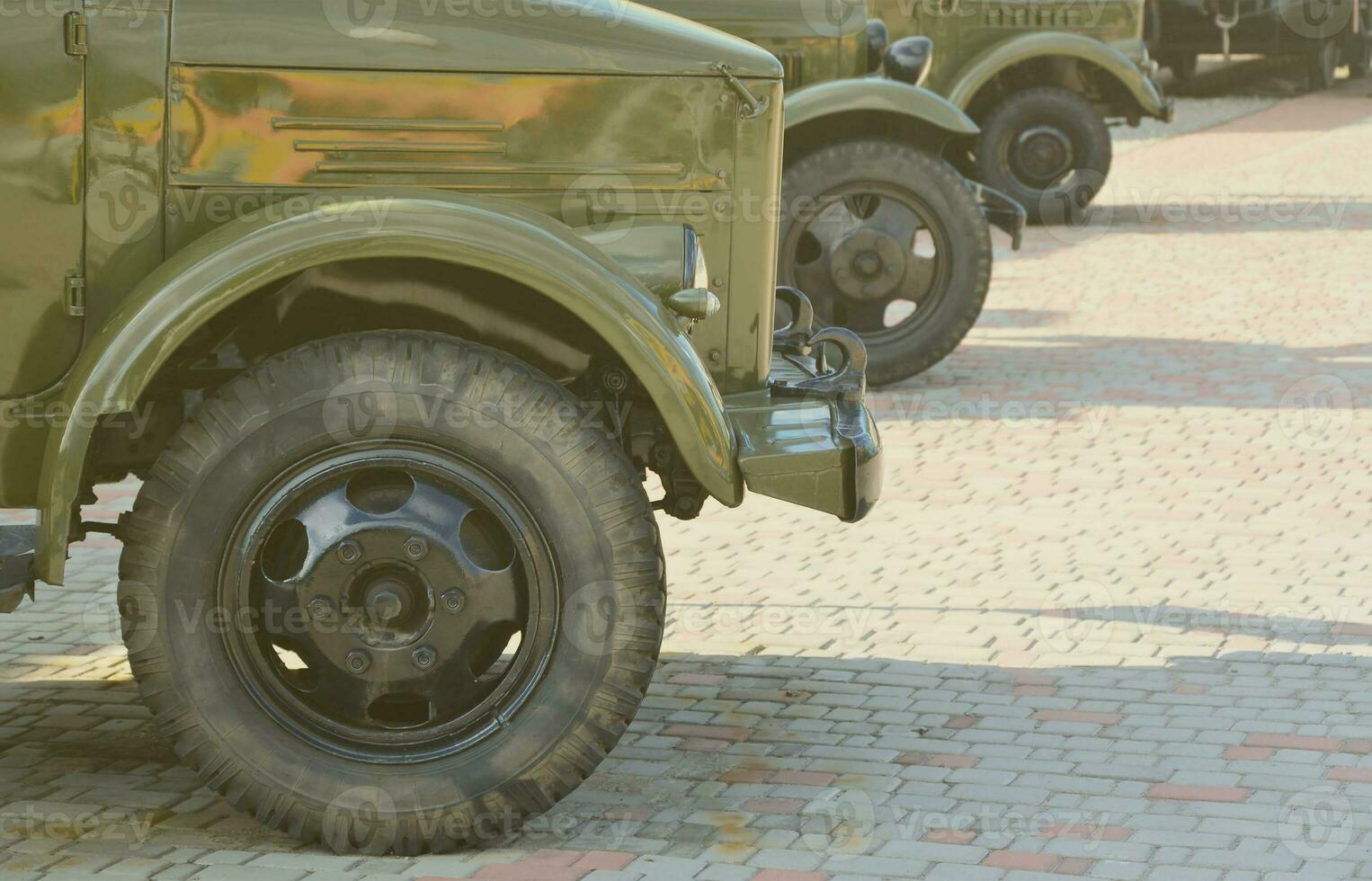 Photo of the cabins of three military off-road vehicles from the times of the Soviet Union. Side view of military cars from the front wheel
