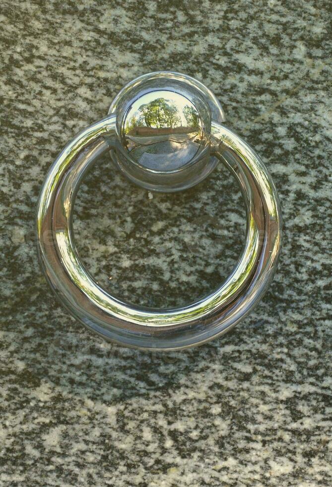 Metal ring on grave of cemetery. Rusty iron handle on granite tomb cover. An 19th century antique cemetery in Lviv photo