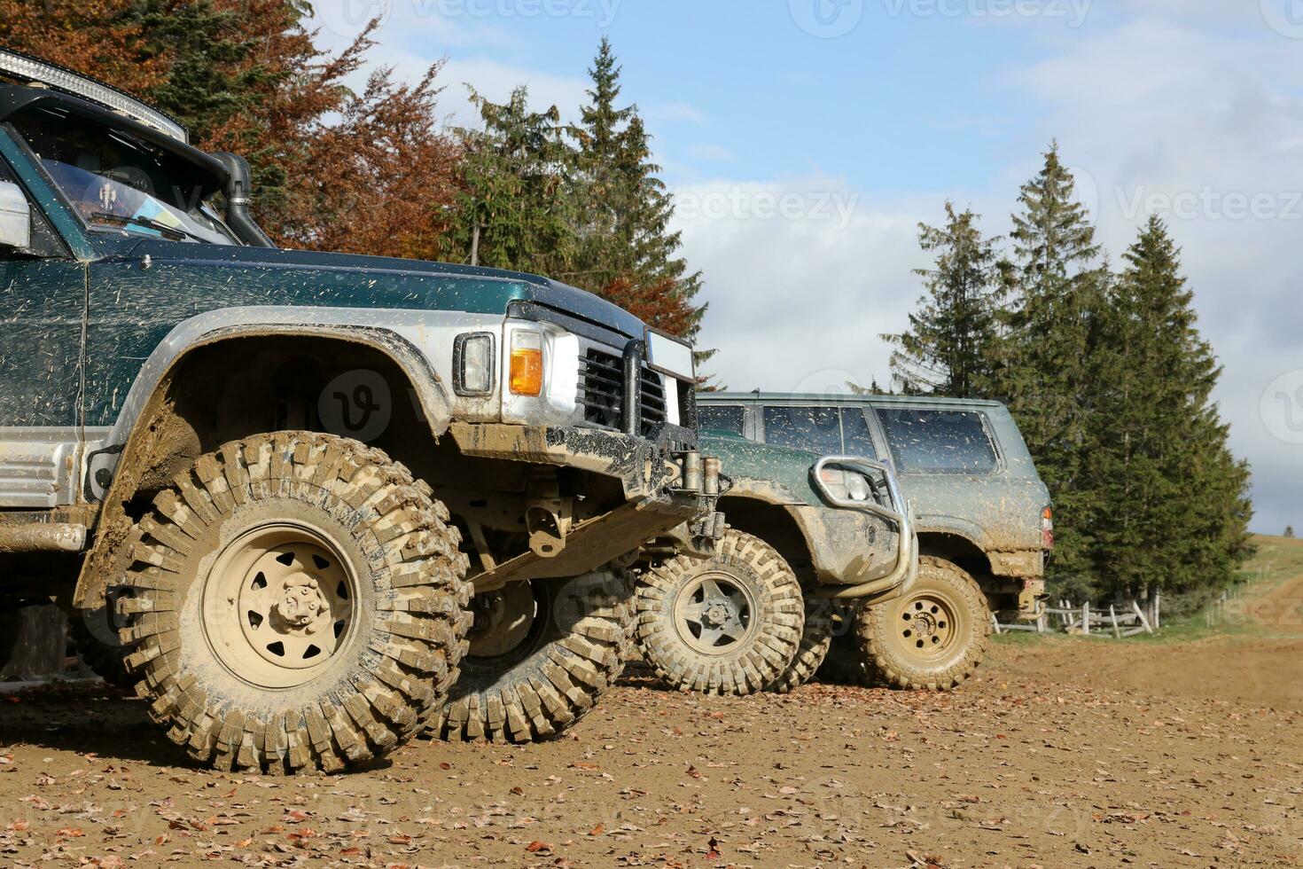 Automobile in a countryside landscape with a mud road. Off-road 4x4 suv automobile with ditry body after drive in muddy road photo