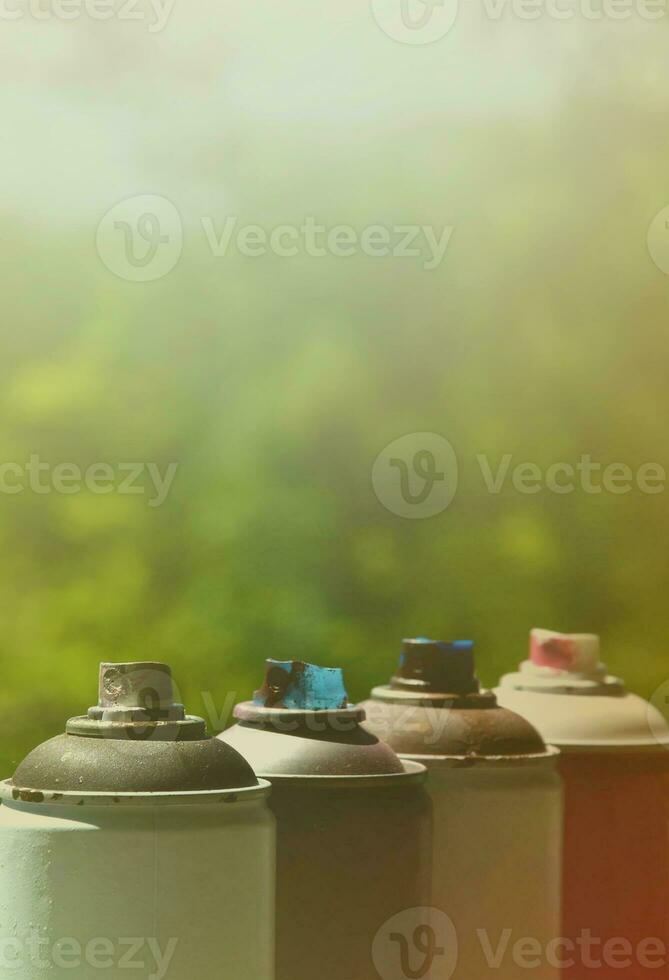 A few used aerosol paint sprayers lie on the windowsill in the workshop of a graffiti artist. The concept of street art and illegal drawing on the walls. Youth hobby photo