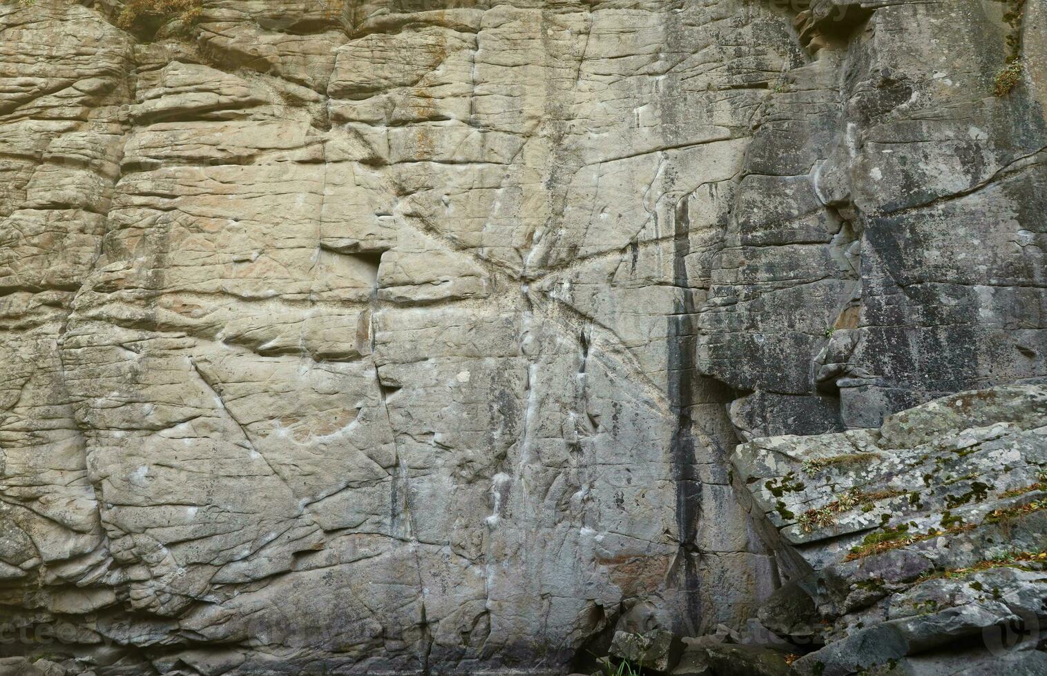 Light coarse natural rock stone background. Mining cliff rough front surface. Big limestone stack backdrop. Heavy grunge damaged granite block texture photo
