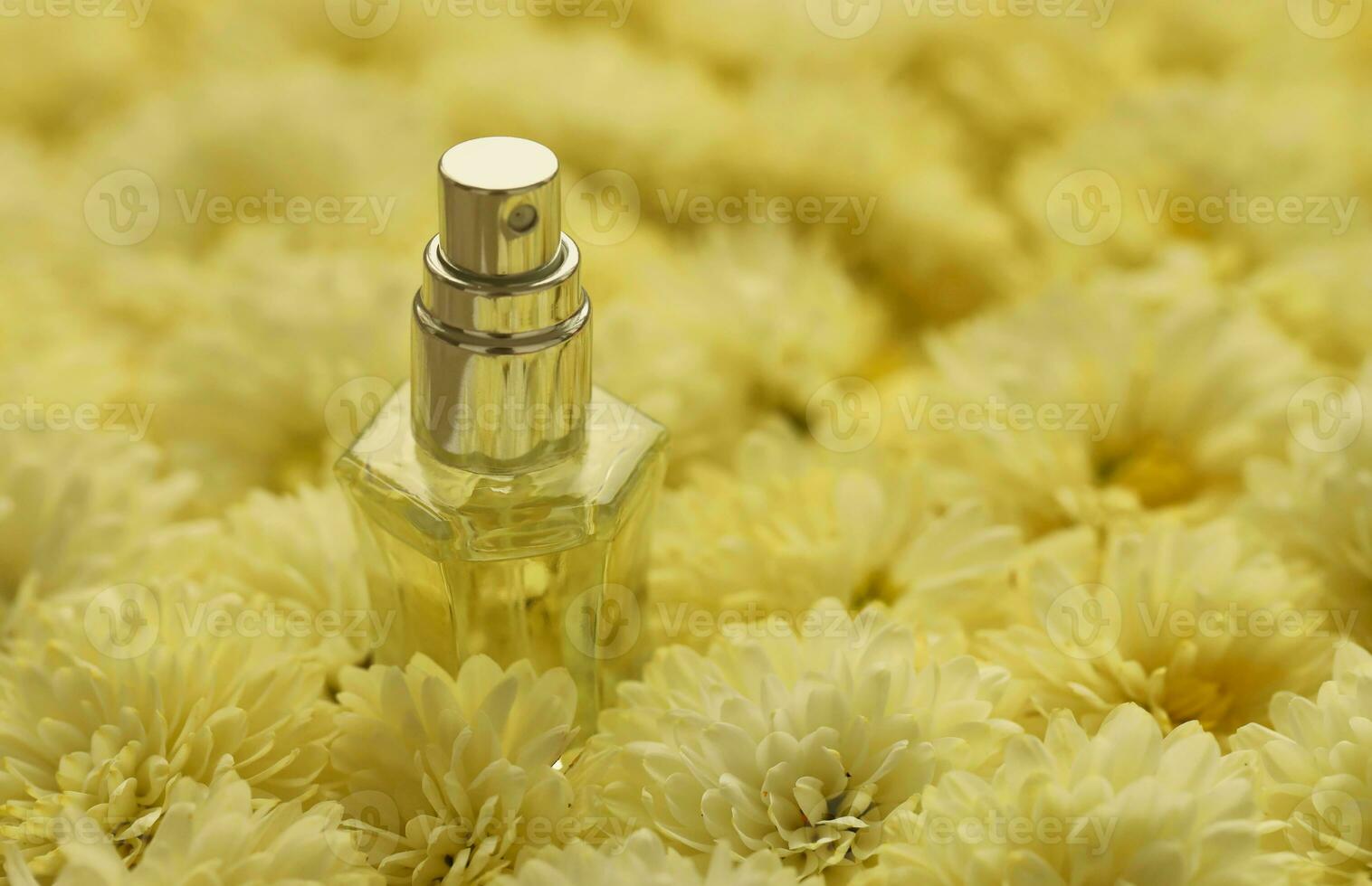 Women fragrance perfume bottle with flowers background close up. Unnamed blank sprayer bottle of perfume photo