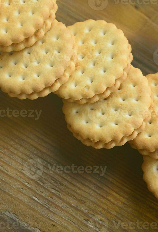 una galleta sándwich redonda con relleno de coco se encuentra en grandes cantidades sobre una superficie de madera marrón. foto de golosinas comestibles sobre un fondo de madera con espacio de copia