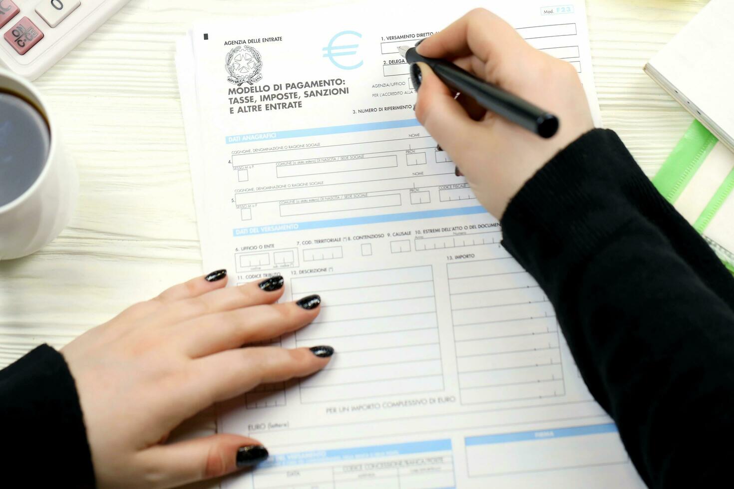 KYIV, UKRAINE - OCTOBER 31, 2023 Accountant fill italian tax form F23 Payment model taxes duties penalties and other revenues in end of tax period. Taxation and paperwork routine photo