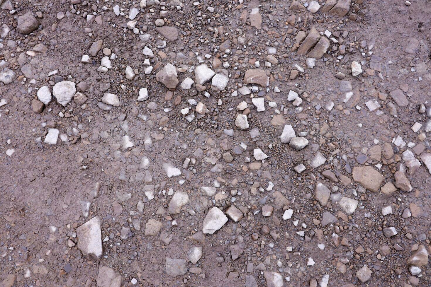 antecedentes de destrozado pedregoso piedras superficie en montaña área. textura con natural ligero foto