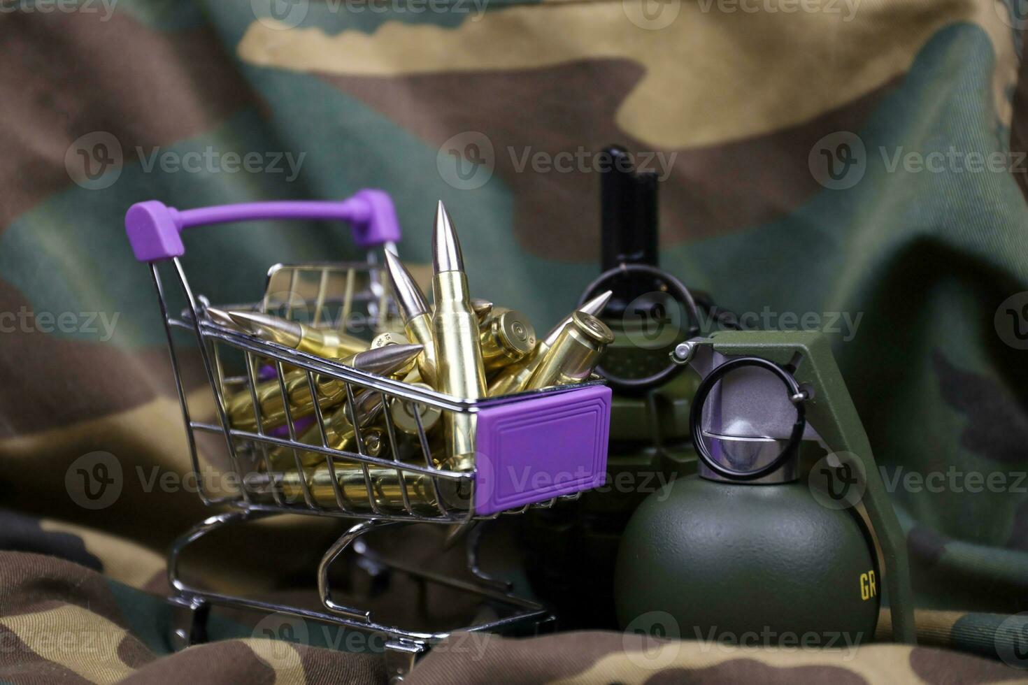 Rifle cartridges in small shopping cart. Big caliber ammo cartridges and hand grenades with a small shopping basket photo