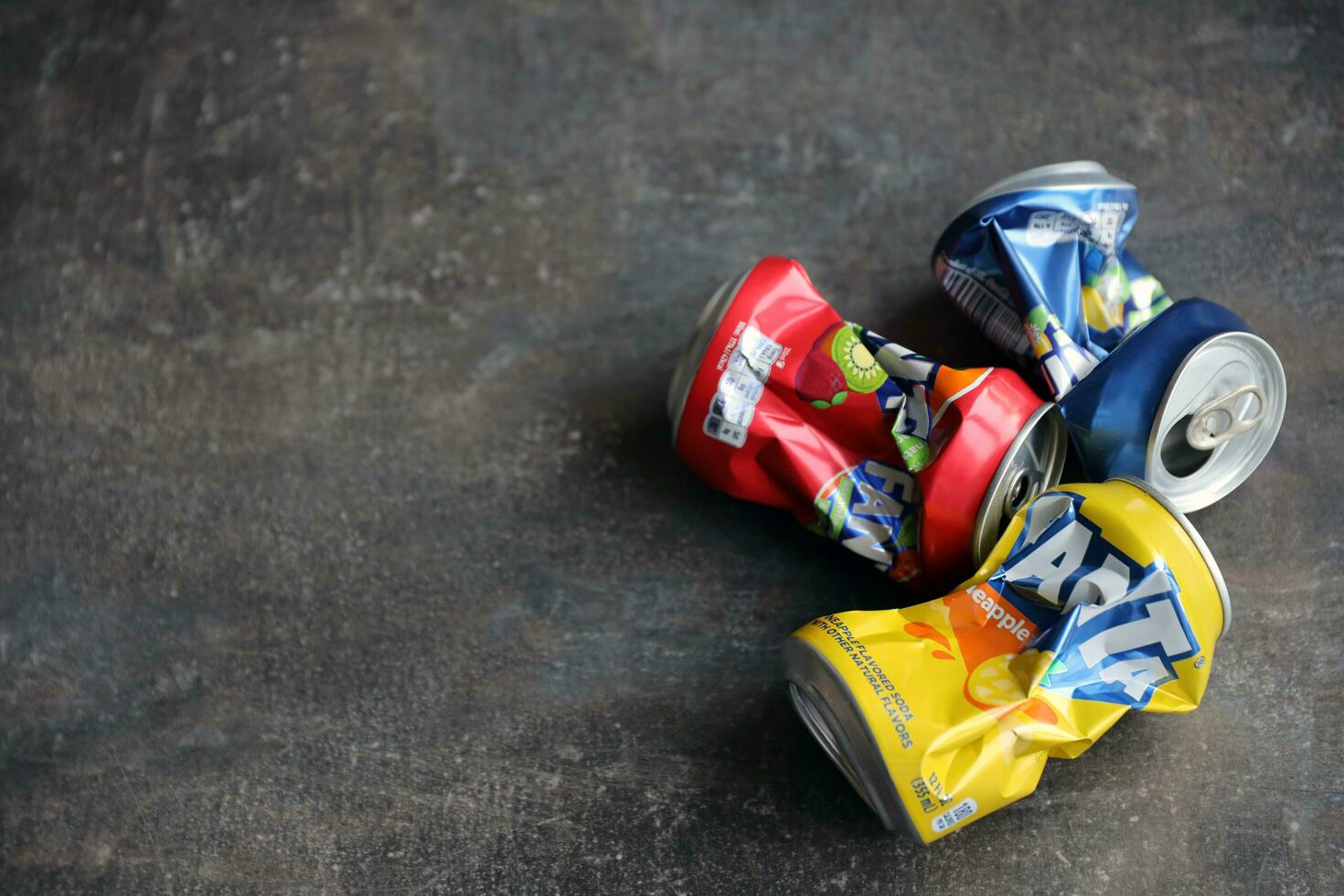 KYIV, UKRAINE - 4 MAY, 2023 Fanta soft drink brand crumpled tin cans with various flavours photo