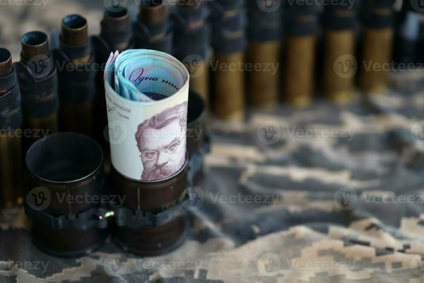 Ukrainian army machine gun belt shells and bunch of hryvnia bills on military uniform. Payments to soldiers of the Ukrainian army, salaries to the military photo