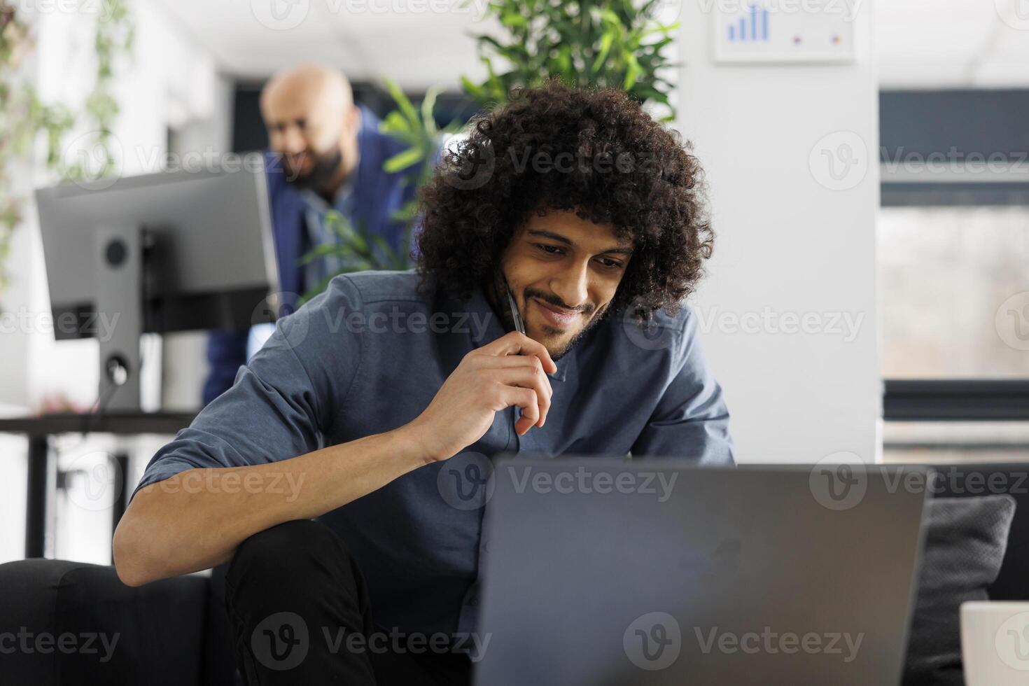 Smiling entrepreneur checking sales revenue growth on laptop while working in business office. Start up company entrepreneur analyzing marketing successful campaign in coworking space photo