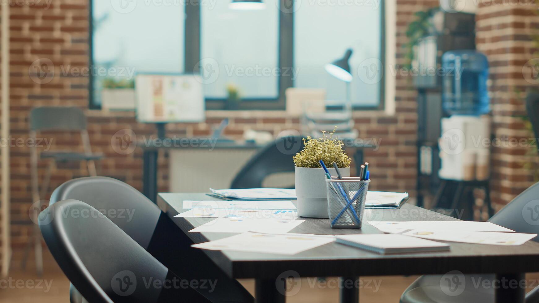 Boardroom meeting place with desks in empty agency office, coworking space filled with workstations and official documents. International startup workplace used for analysis and reviewing work. photo