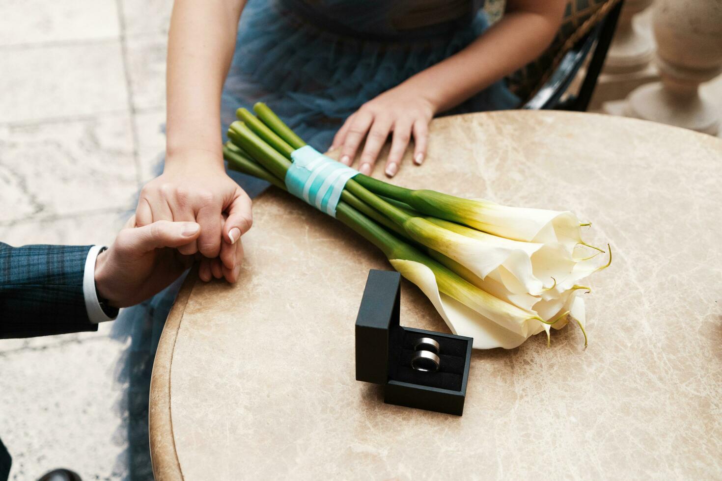 wedding rings and a bouquet of lilies, a couple holding hands photo