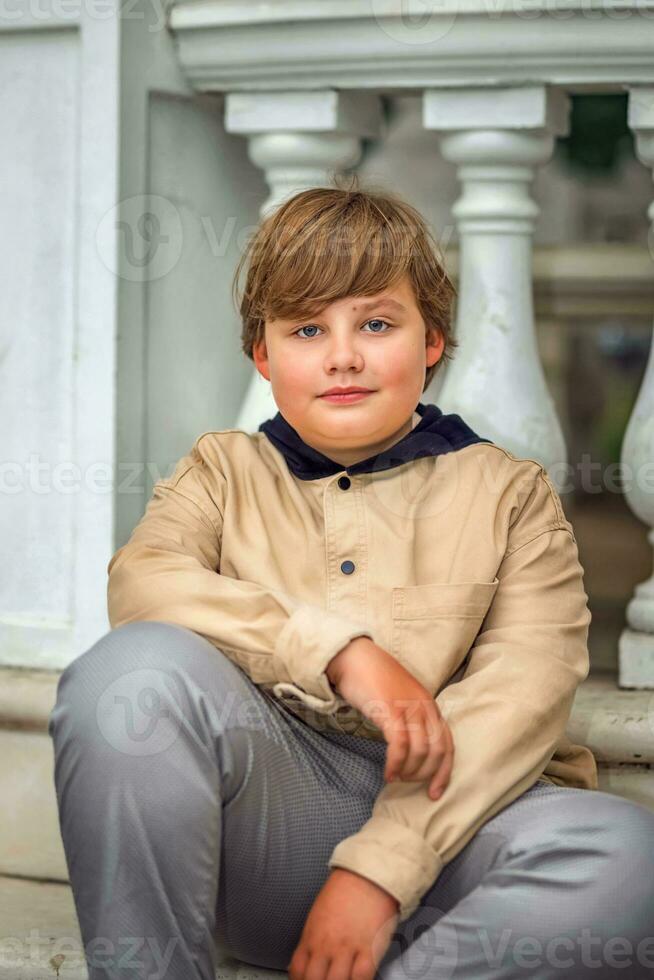 A young handsome boy of European appearance likes to spend time outside. Not staged portraits of a boy. It's a great time to relax. photo