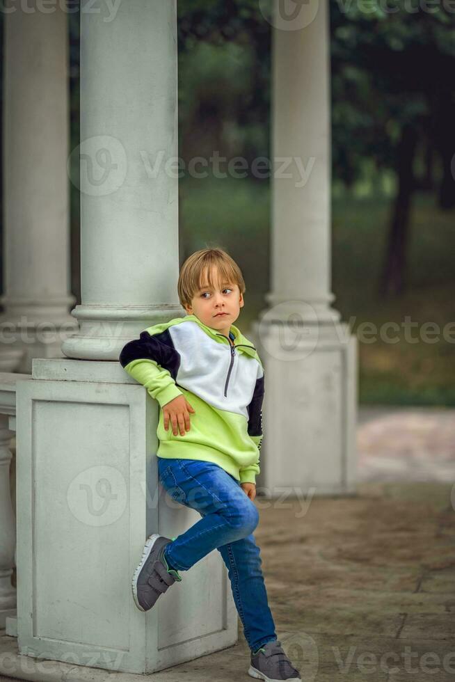 A young handsome boy of European appearance likes to spend time outside. Not staged portraits of a boy. It's a great time to relax. photo