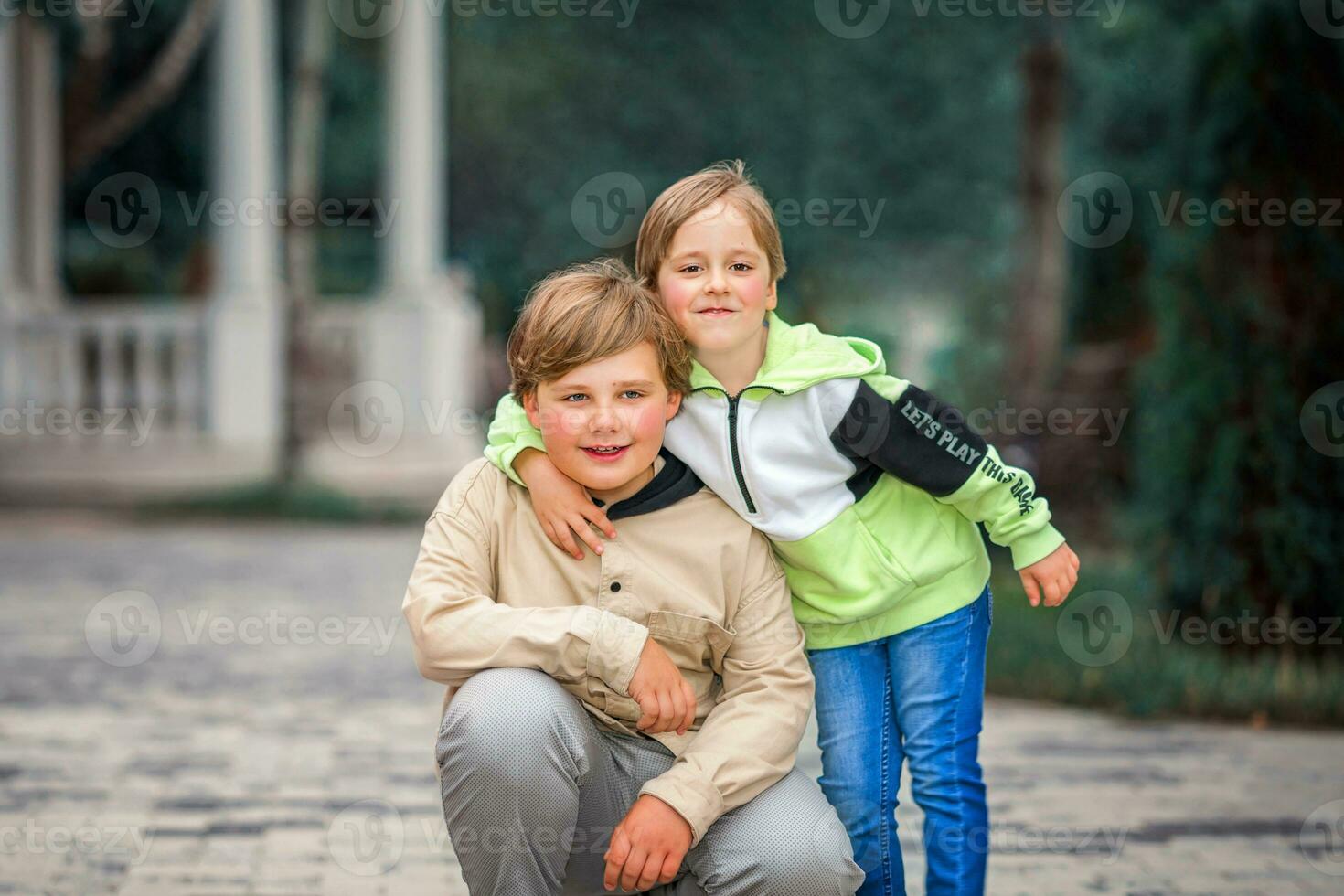 Two brothers, two Young handsome boys of European appearance, enjoy spending time on the street. It's a great time to relax. photo