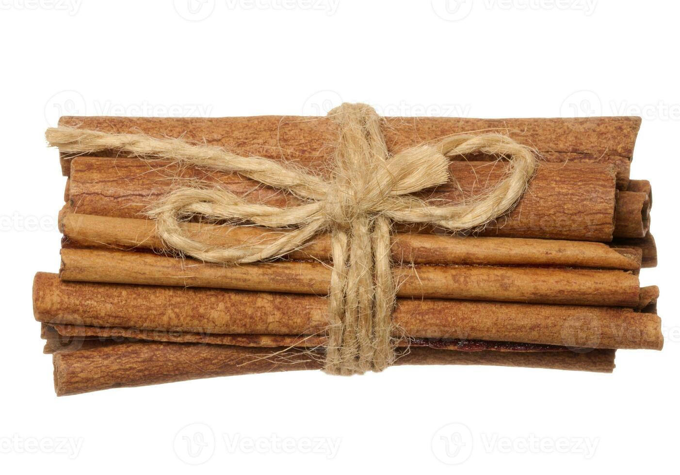 Dry cinnamon sticks tied with brown jute rope on a white isolated background photo