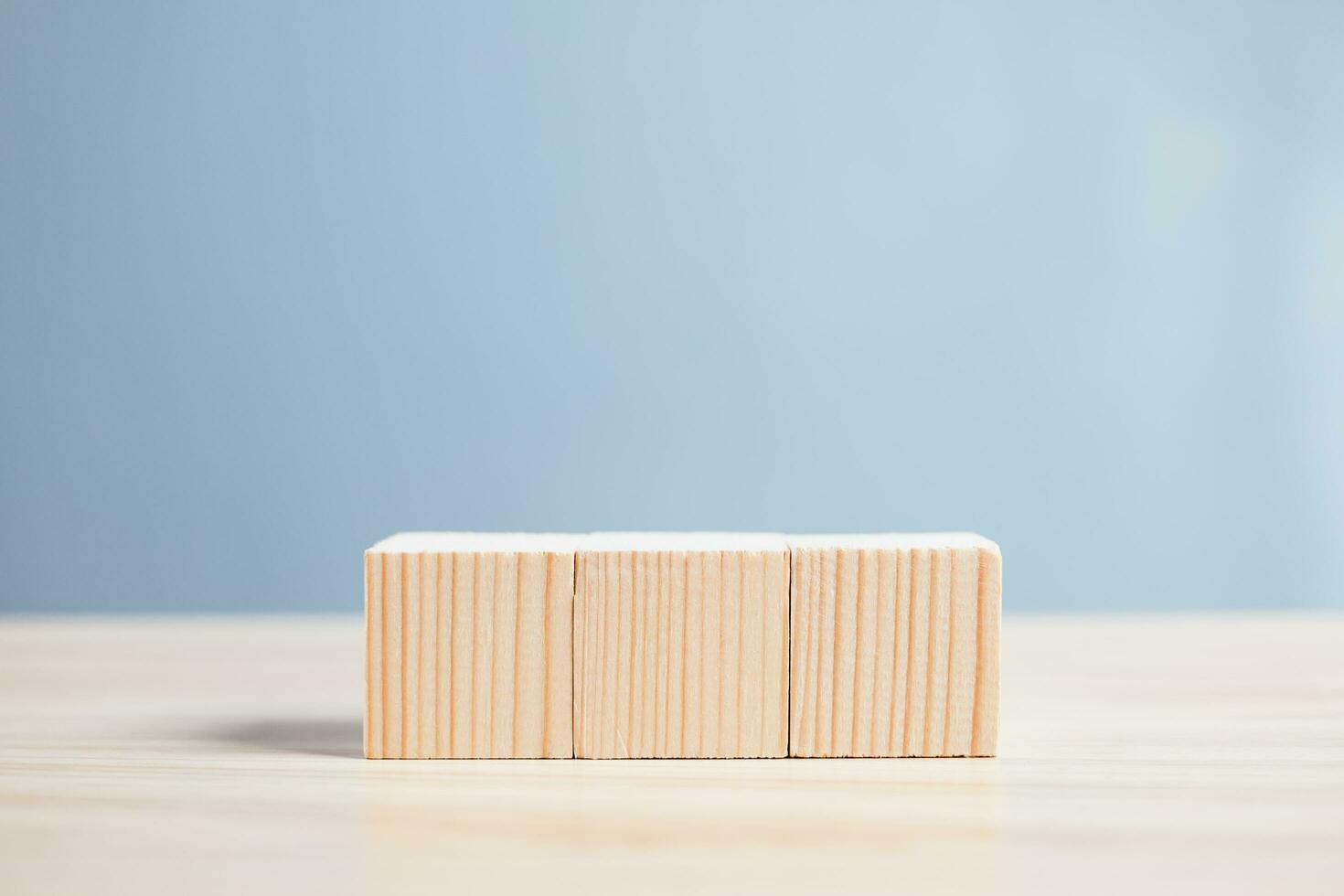wood empty three blocks on table and blue blackground with copy space for text or symbols, development concept for growth success process. photo