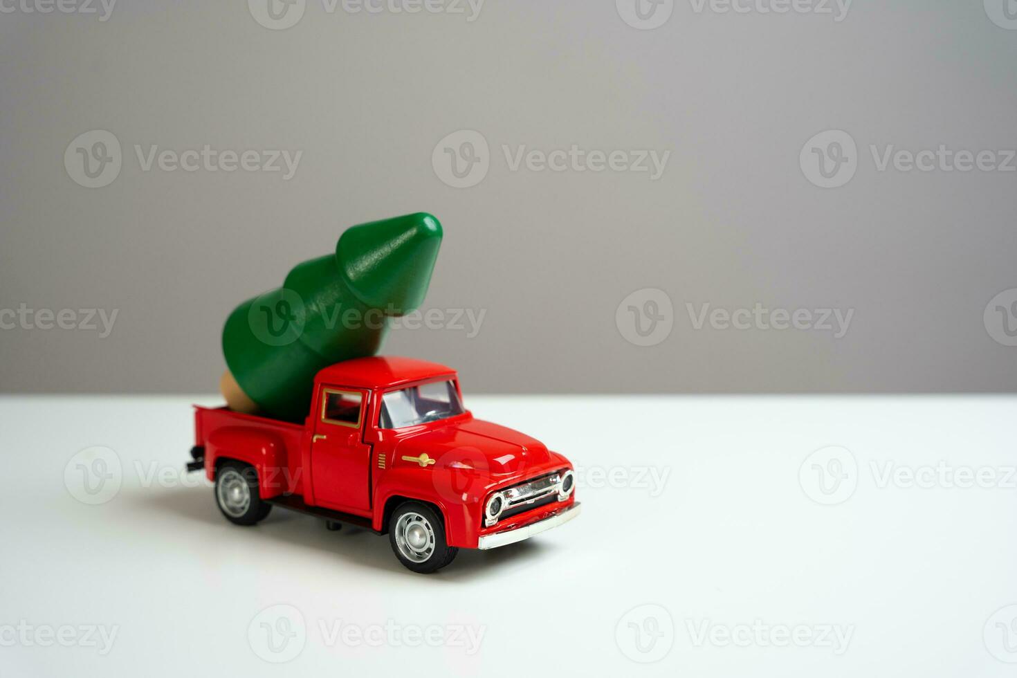 A old-fashioned red pickup truck with a Christmas tree in the back. Evoking memories, joy of the season. The classic charm and timeless spirit. Buy a Christmas tree. Going on a New Year's trip. photo
