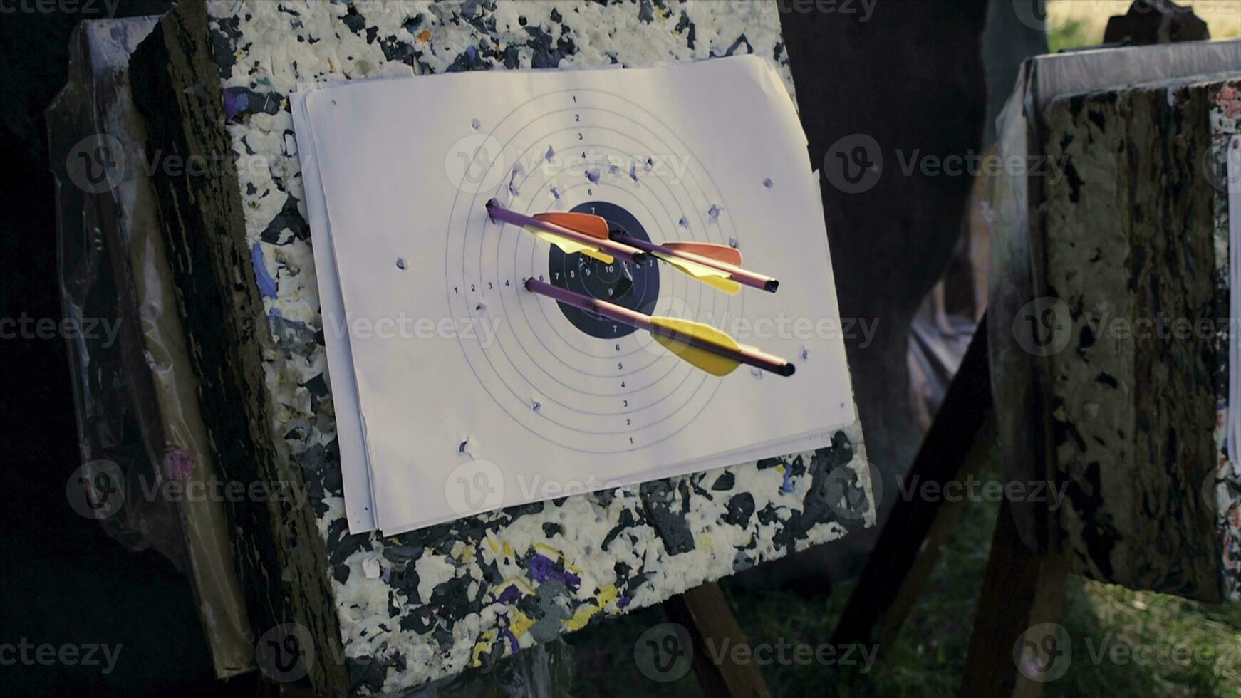 Arrow in the wooden target. Clip. Archery target. Series of straw archery targets in wooden stands. An outdoor target for shooting with a bow and arrows on a summer day on the streets photo