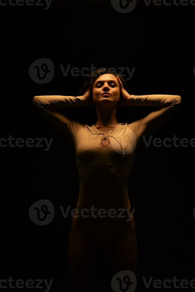 Woman stands on dark background photo