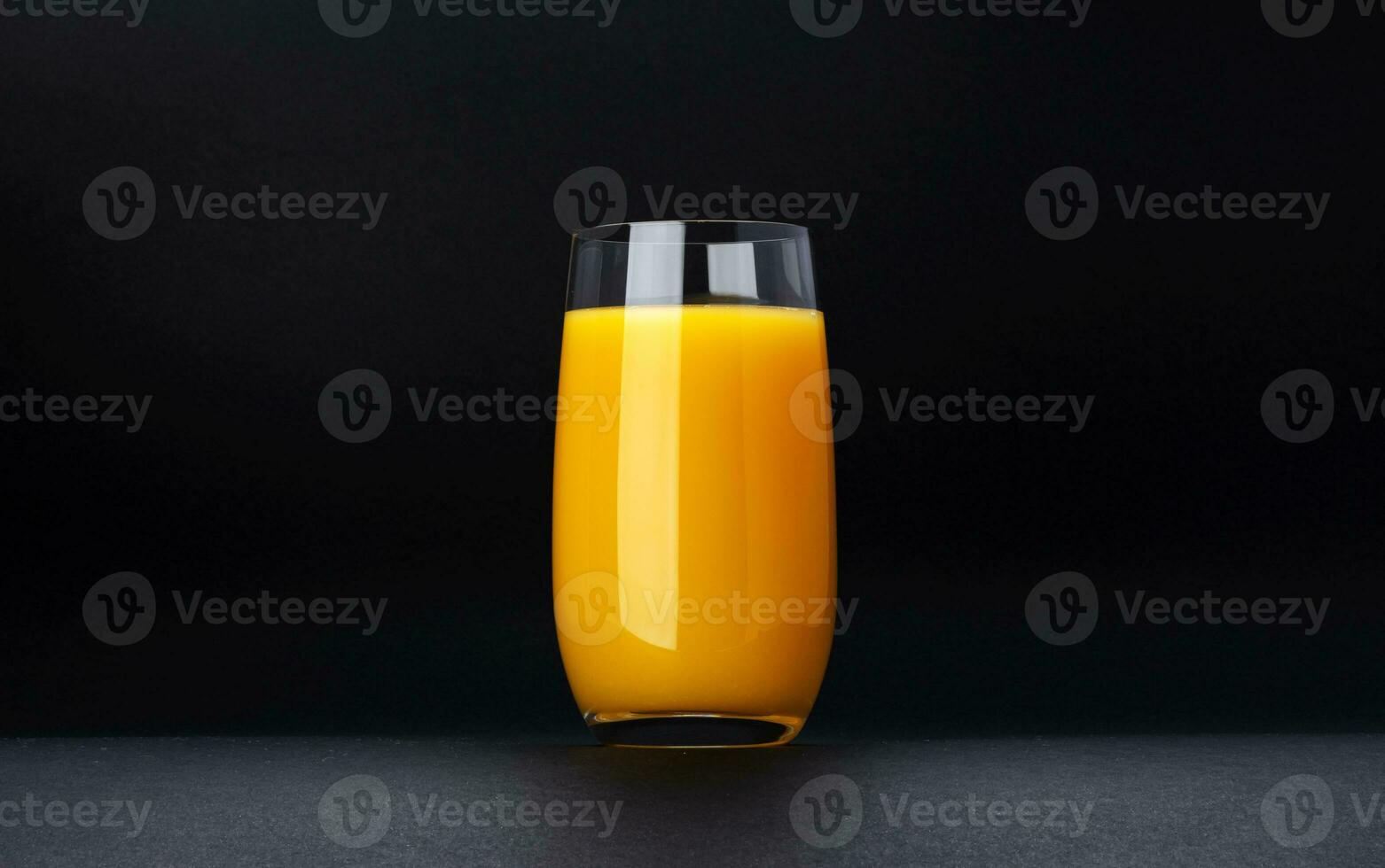 Glass of orange juice isolated on black background with copy space photo
