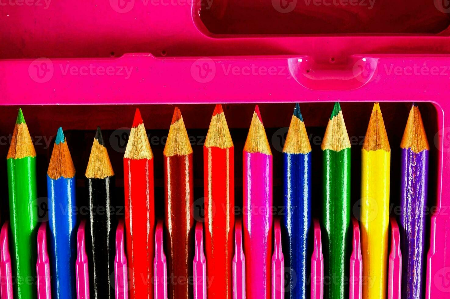 a pink pencil case with several colored pencils photo