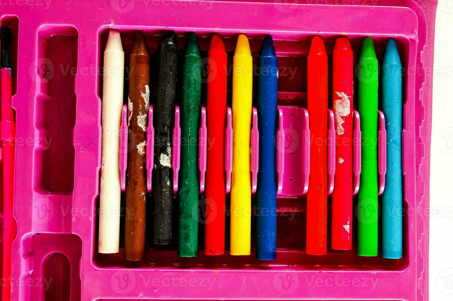 a pink plastic case with several crayons in it photo