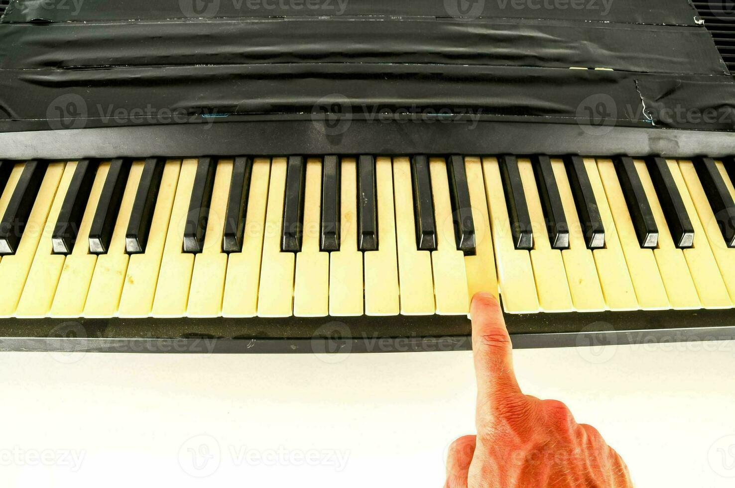 a person is playing a key on the keyboard photo