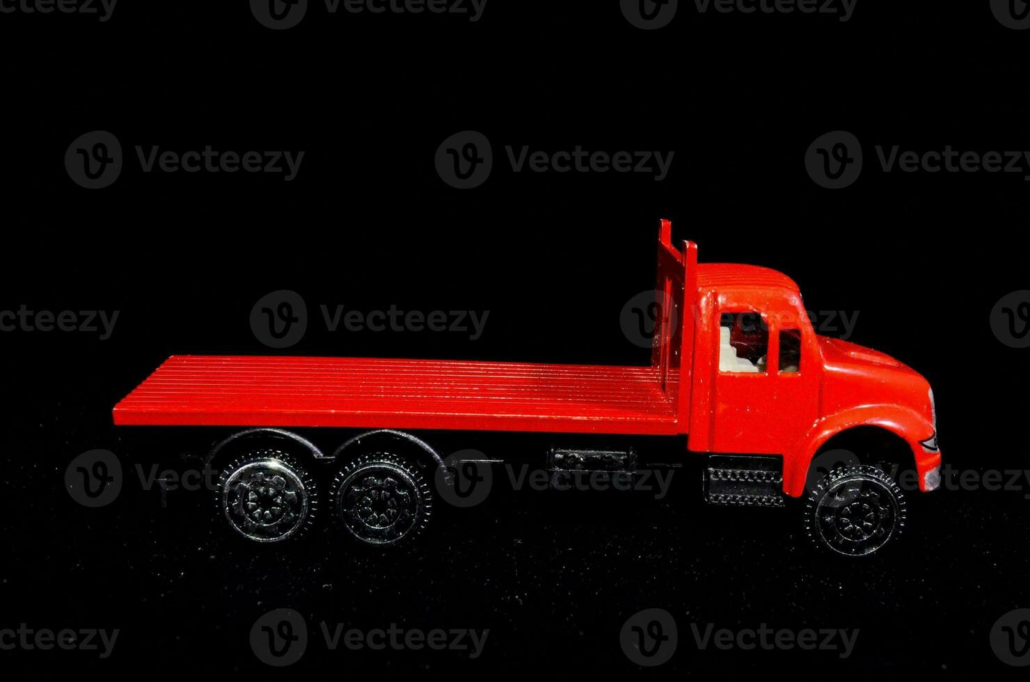 a red toy truck is shown against a black background photo