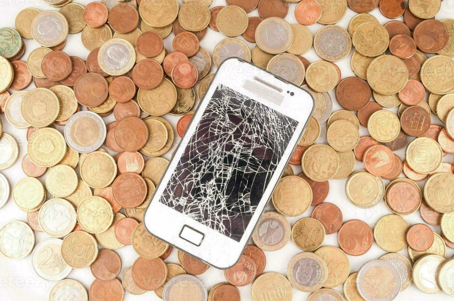a cracked phone on coins photo