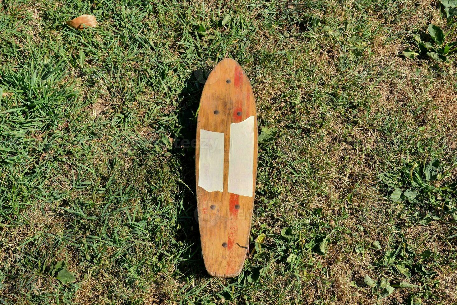 a wooden skateboard laying on the grass photo
