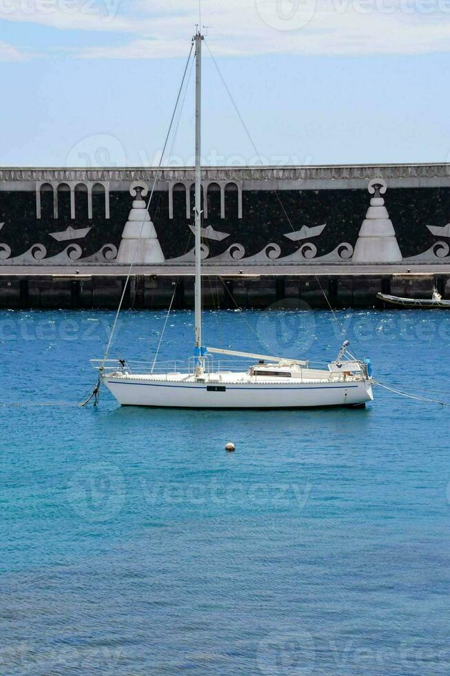 a sailboat in the harbor of santorini, greece photo