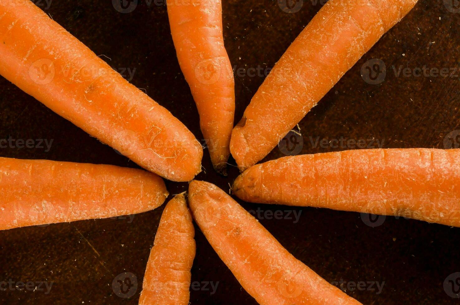 carrots arranged in a circle on a wooden surface photo