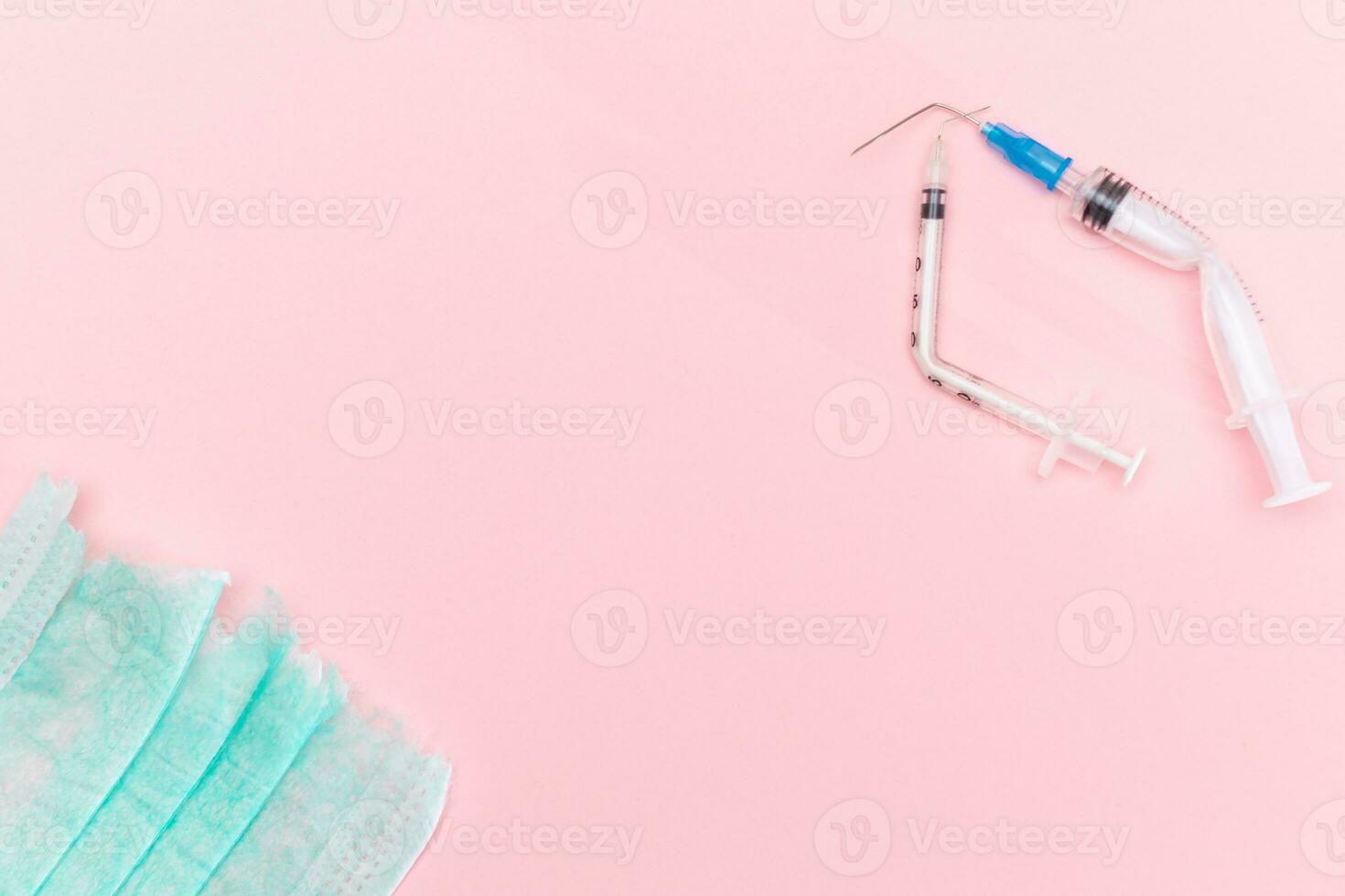 Anti Vaccine Movement and Anti Mask Concept - Broken Medical Syringe and Green Torn Medical Face Mask on the Pink Background. Pandemic and Lockdown End - Top View, Flat Lay photo