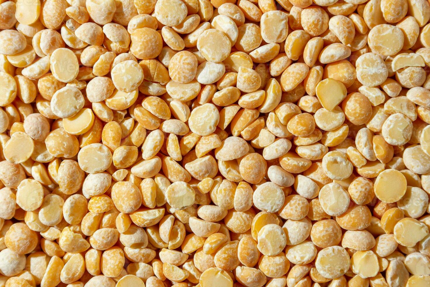 Uncooked Polished Split Peas Background. A Culinary Canvas of Dry Yellow Peas, Creating a Lively and Textured Background for Gourmet Cooking. Scattered Raw Polished Peas. Healthy Eating Ingredients photo