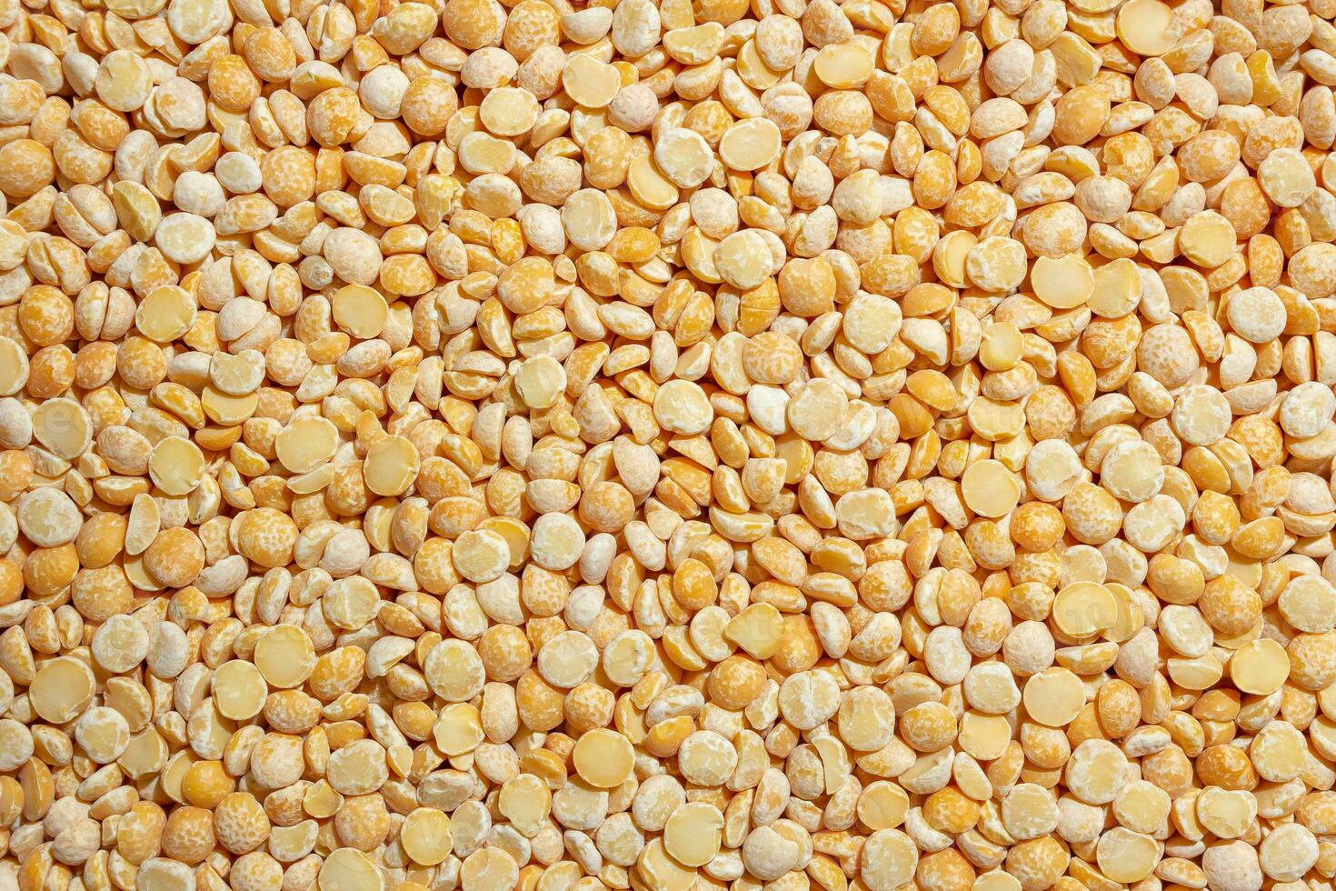 Uncooked Polished Split Peas Background. A Culinary Canvas of Dry Yellow Peas, Creating a Lively and Textured Background for Gourmet Cooking. Scattered Raw Polished Peas. Healthy Eating Ingredients photo