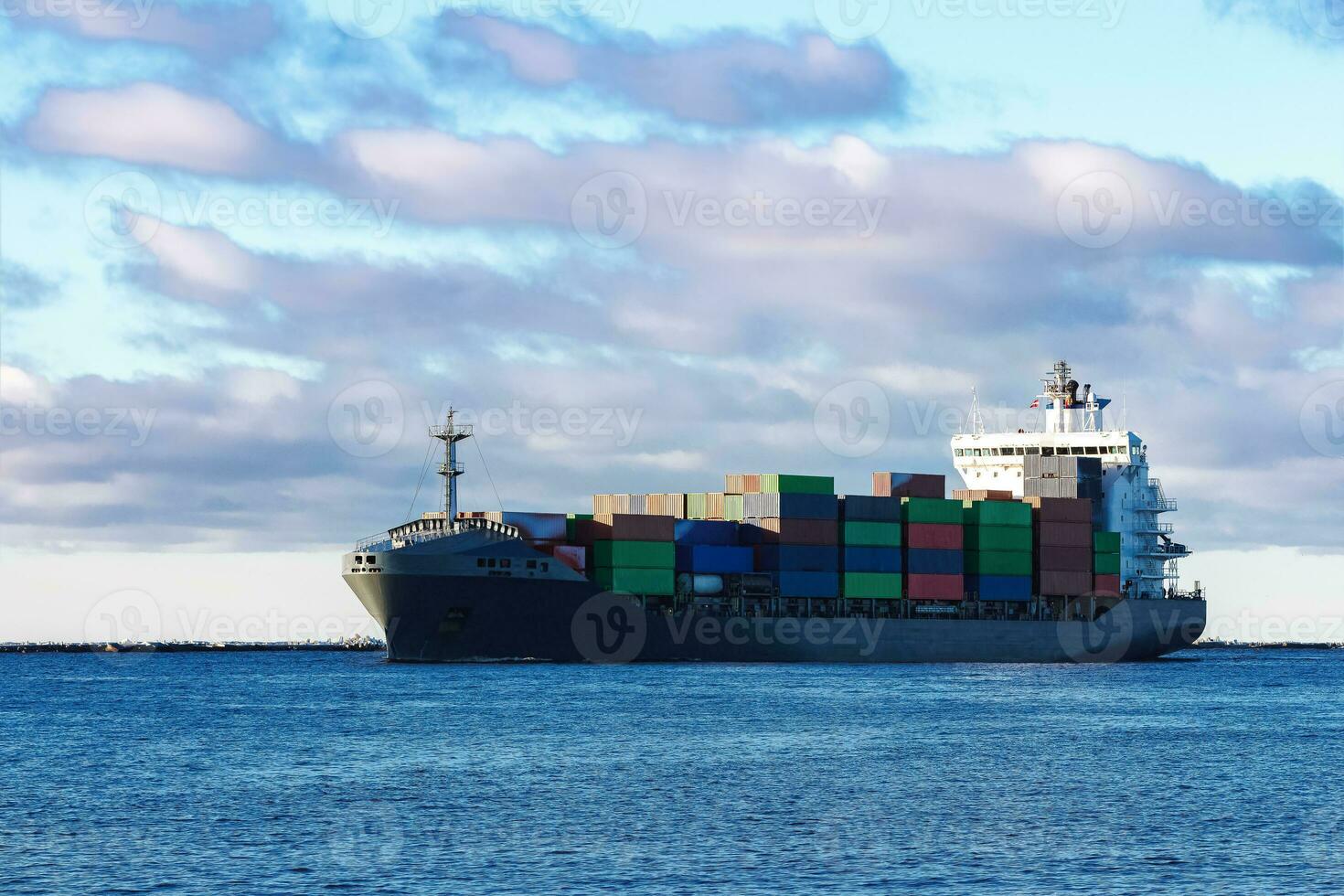 Modern grey container ship moving in still water photo