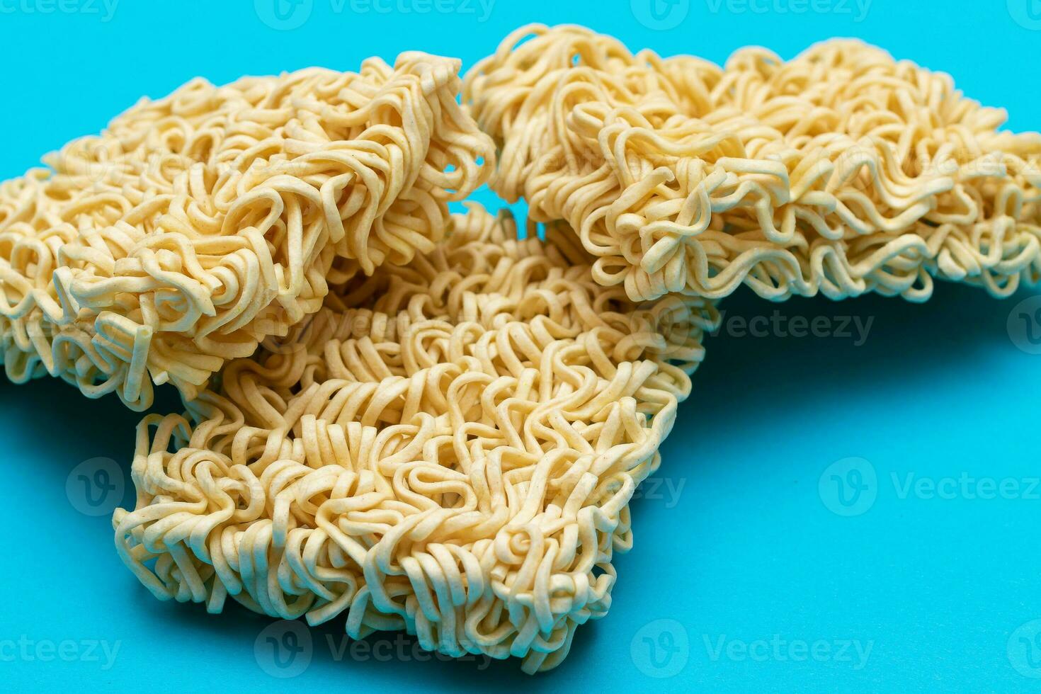 Uncooked Instant Noodles on Blue Background. Raw Pasta. Dry Asian Fast Food. Quick Lunch photo