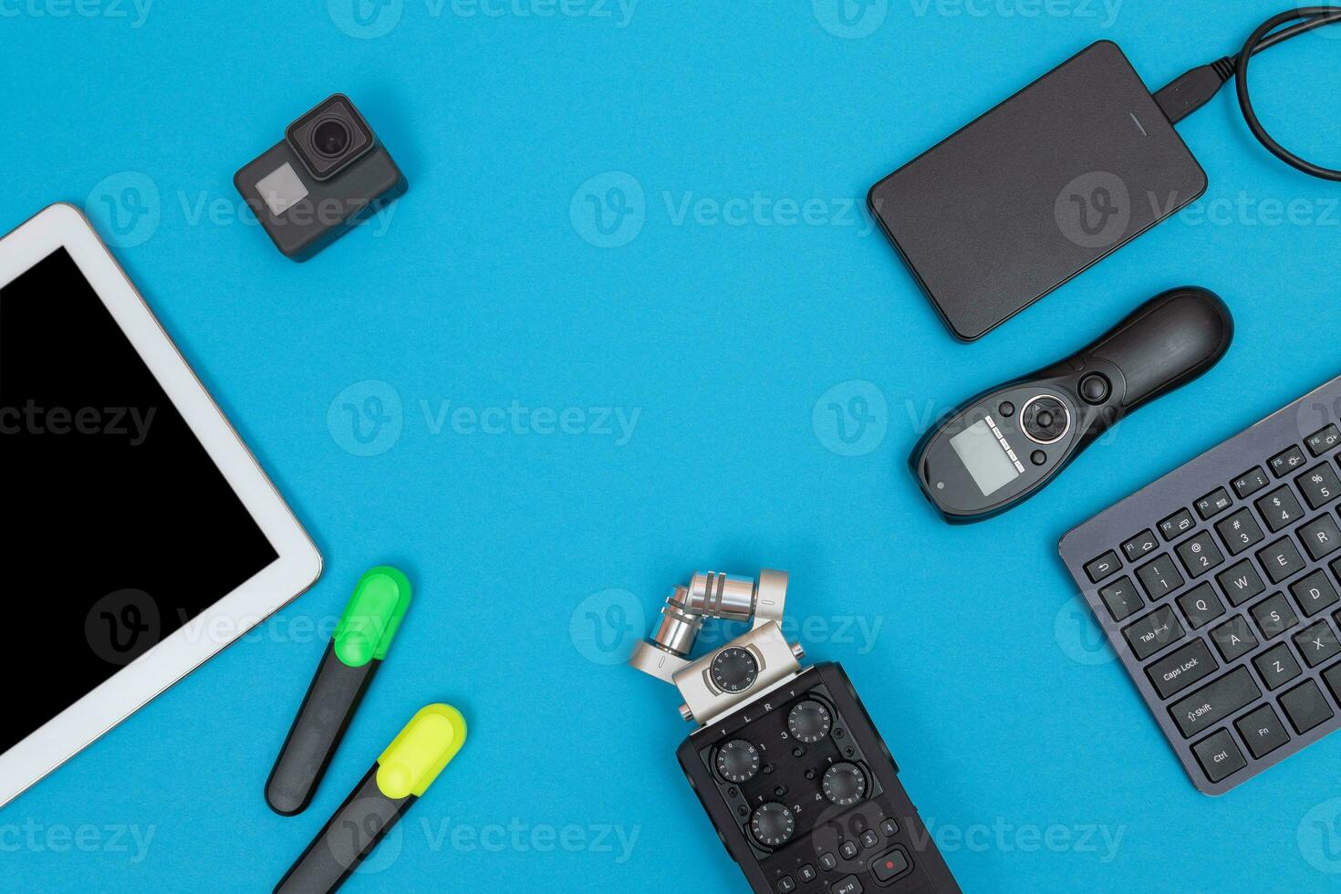 Top View of Photographer's, Videographer's or Video Blogger's Workplace. Digital Gadgets Lying on Blue Table Flat Lay photo