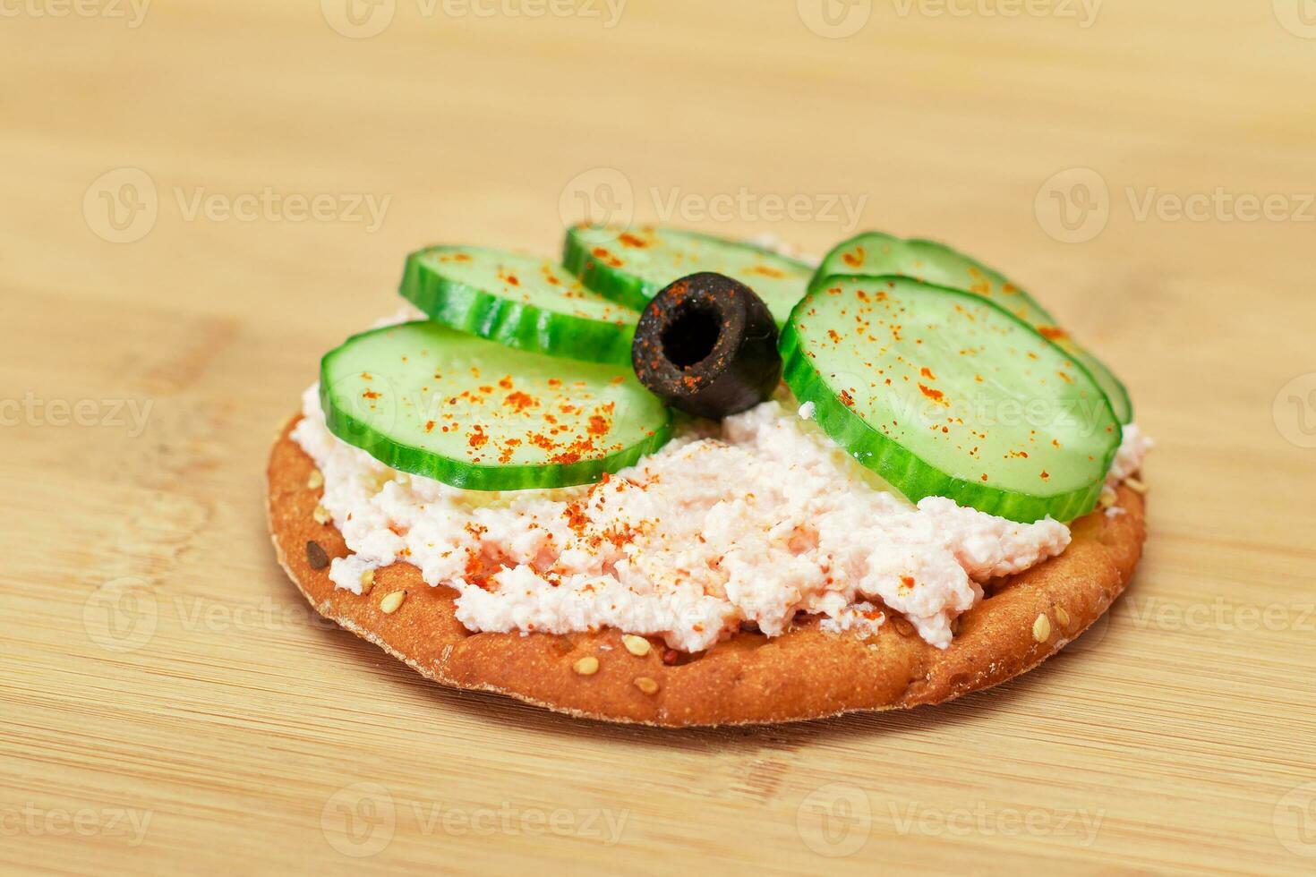 Crispy Cracker Sandwich with Fresh Cucumber, Fish Cream and Olives on Cutting Board. Easy Breakfast. Quick and Healthy Sandwiches. Crispbread with Tasty Filling. Healthy Dietary Snack photo