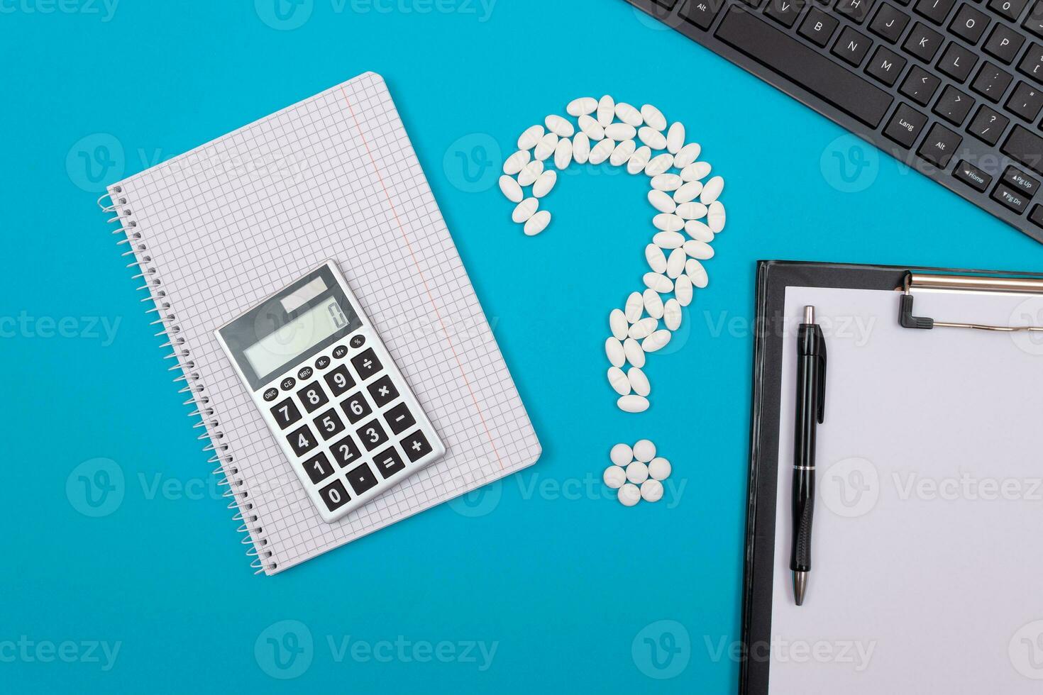 Treatment Costs and Budget. Question Mark Made from White Pills and Tablets with Calculator and Notepad, Lying on Blue Background. Global Pharmaceutical Industry and Medicinal Products photo