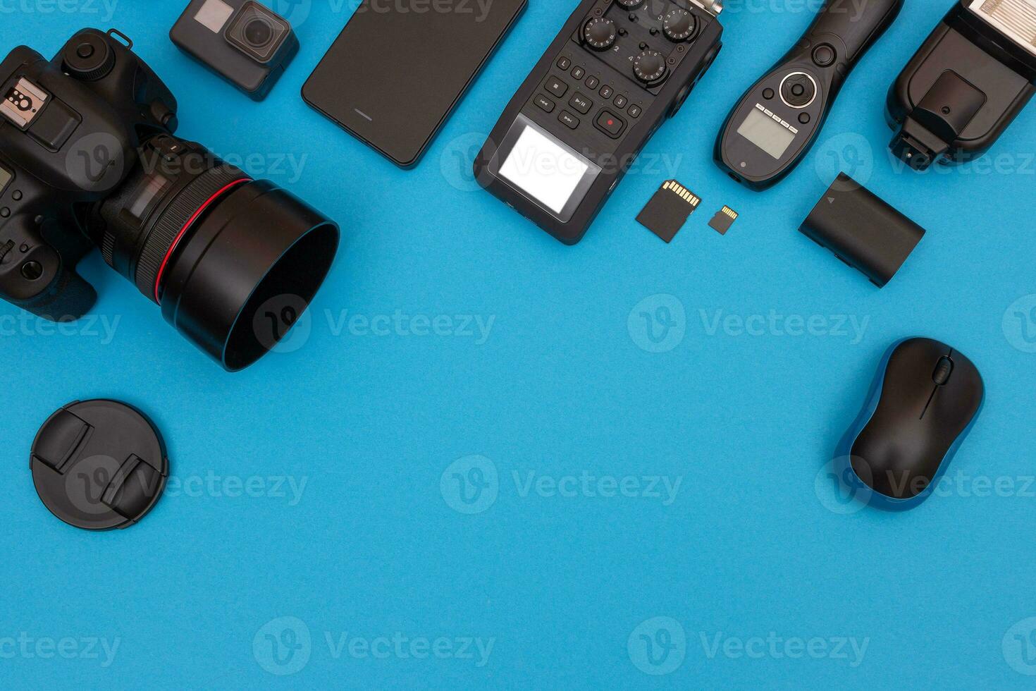 Top View of Photographer's, Videographer's or Video Blogger's Workplace. Digital Gadgets Lying on Blue Table Flat Lay photo