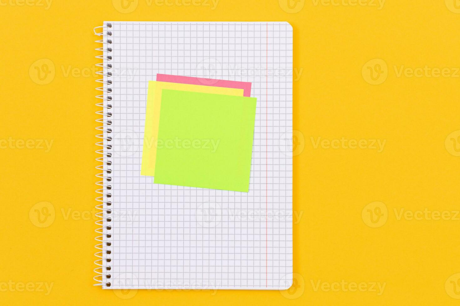 A Notepad with Sticky Notes Lying on Yellow Table Blank Template. Top View, Flat Lay photo