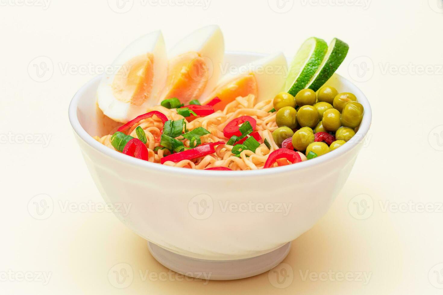 Beautiful Noodle Dish with Green Pea, Eggs, Red Hot Pepper, Greens and Lime on White Background. Instant Noodles photo
