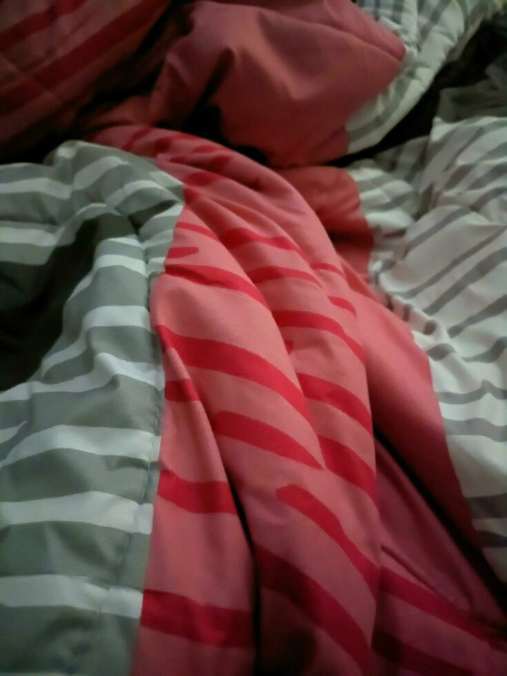 The background of the blanket is striped with pink and gray colors photo